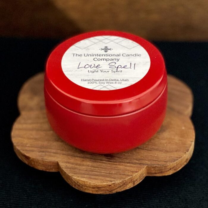 Scented red candle tin on rustic wood shelf