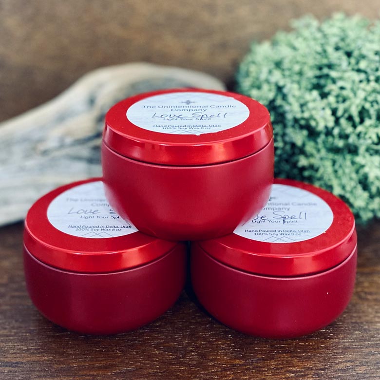 Three scented candle tins in a natural setting