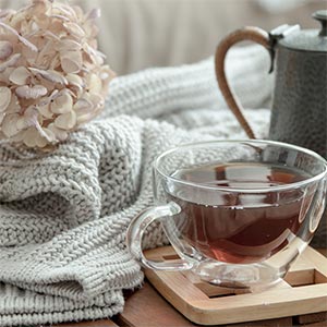 Cup of hot tea amid knitted items